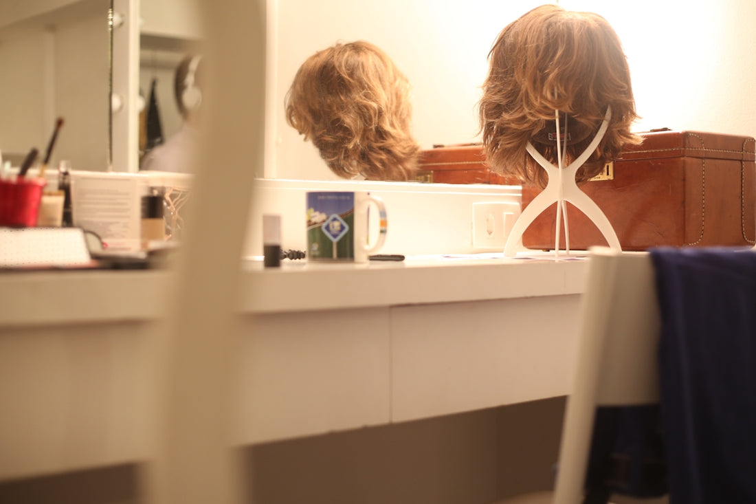 brown wig on rack in front of mirror